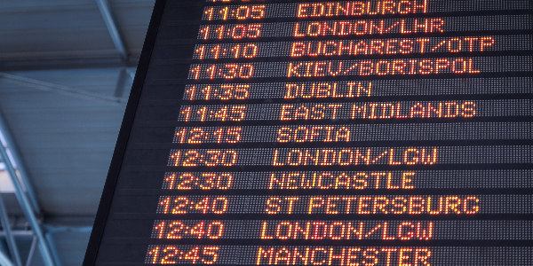 airport flight board showing international destinations as a sign for companies to consider managing risks better