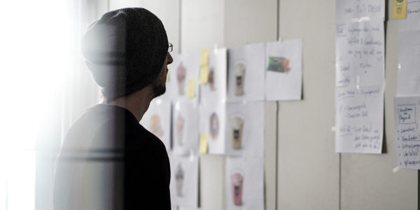 employee staring at a project board, symbolizing an individual's search for the right job and how important employee benefits for staff retention is