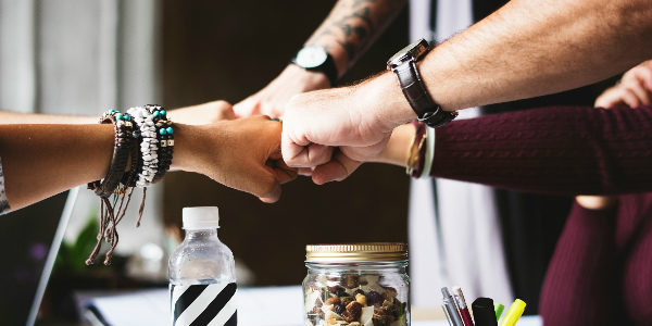 employees fist bump after a successful employee benefits planning session