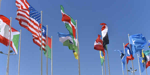 multiple country flags fly in the wind representing the challenge of international employee benefits