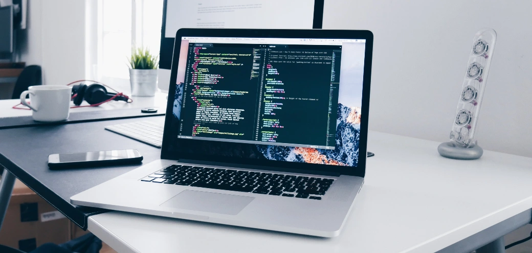 A MacBook with programming windows on the screen