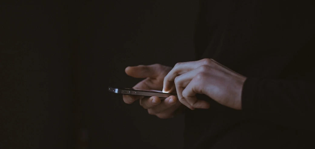 A person using a mobile phone in a dark room
