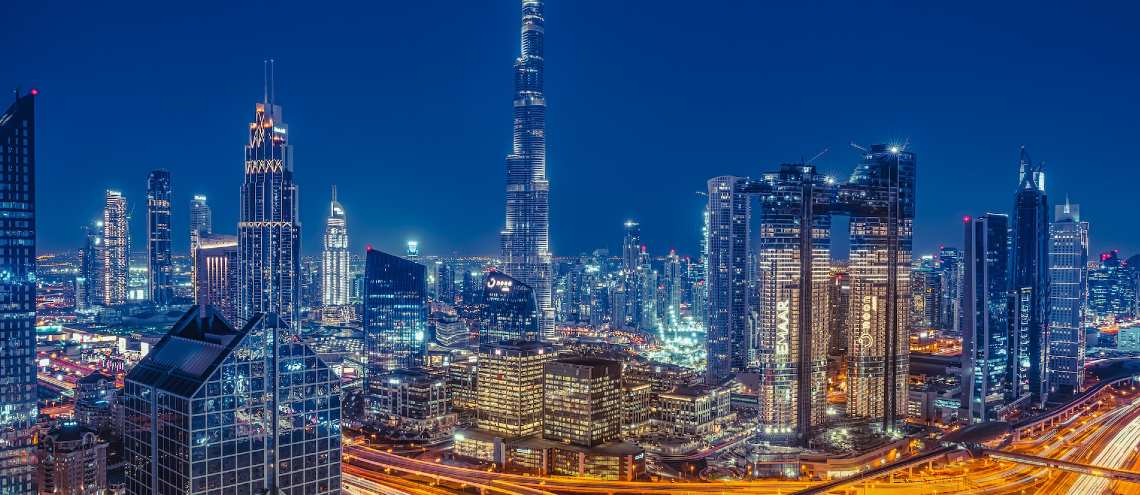 Dubai UAE skyline at night with lit up buildings and streets 