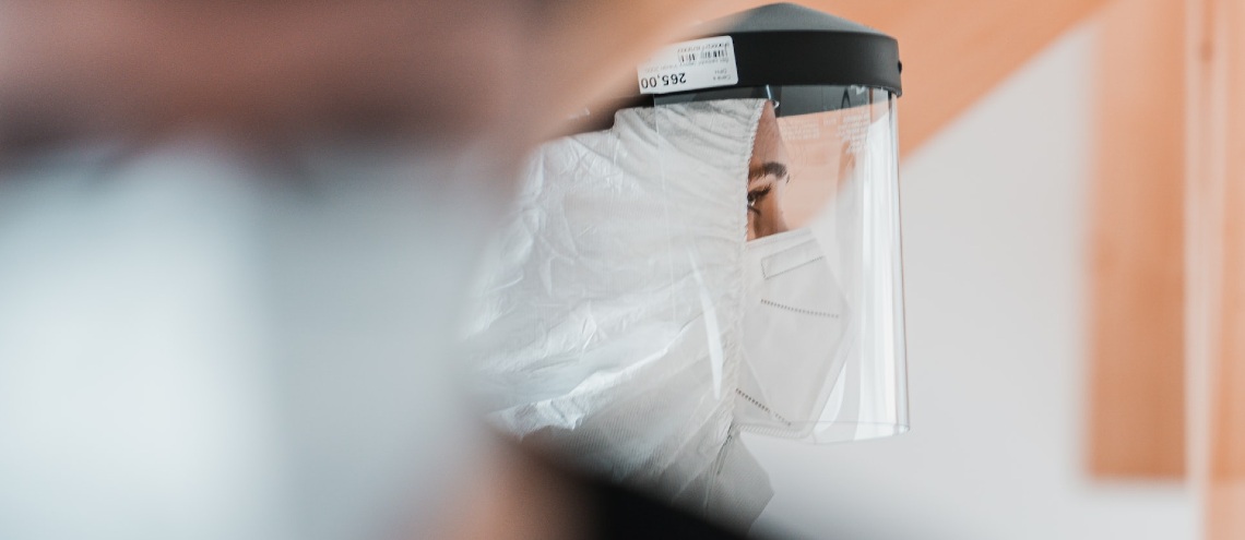 Woman wearing protective face shield and medical gear