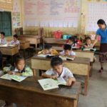 students read at their desks in a room to read and pacific prime built school in laos