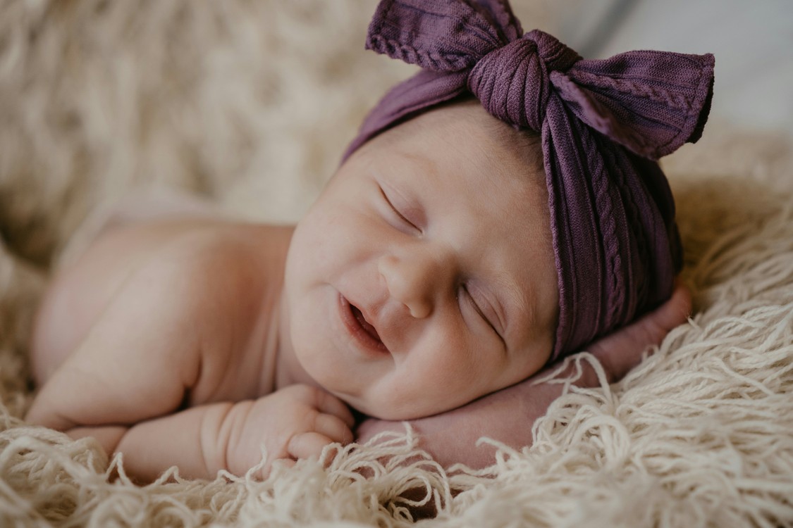 Baby With Purple Cap On White Fur
