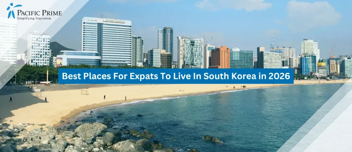 Image of Blue Beach Coastline Under Clear Skies In Busan, South Korea with text overlay of "Best Places For Expats To Live In South Korea in 2026"