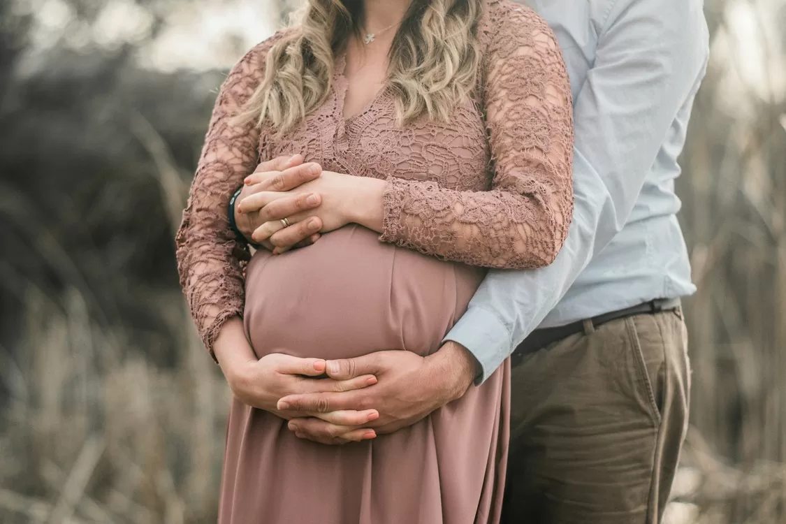 Couple's Hands Around Pregnant Belly