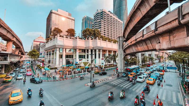 Daytime Thai Street: Cars Near Buildings