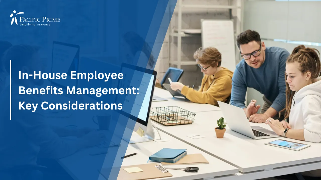Image of Employees Working Together At Computers In A Modern Office with text overlay of "In-House Employee Benefits Management: Key Considerations"