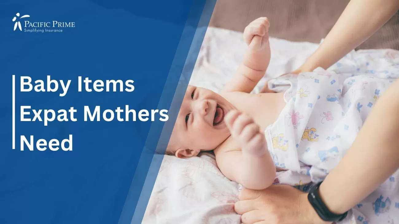 Image of a Happy Baby With Woman's Arm On Bed - Expat Maternity Essential with text overlay of "Baby Items Expat Mothers Need"