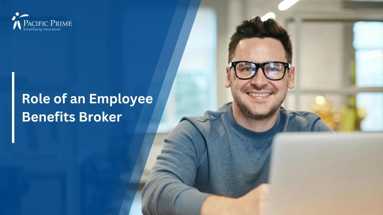 Image of a Happy Man With Glasses Using Laptop In Bright Office Setting with text overlay of "Role of an Employee Benefits Broker"