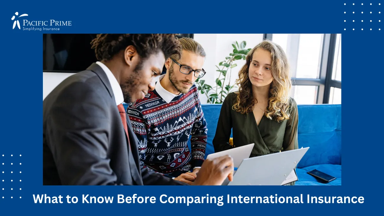 Image of Man In Black Suit And Woman In Blue And White Dress Discussing Insurance Plans with text overlay of "What to Know Before Comparing International Insurance"