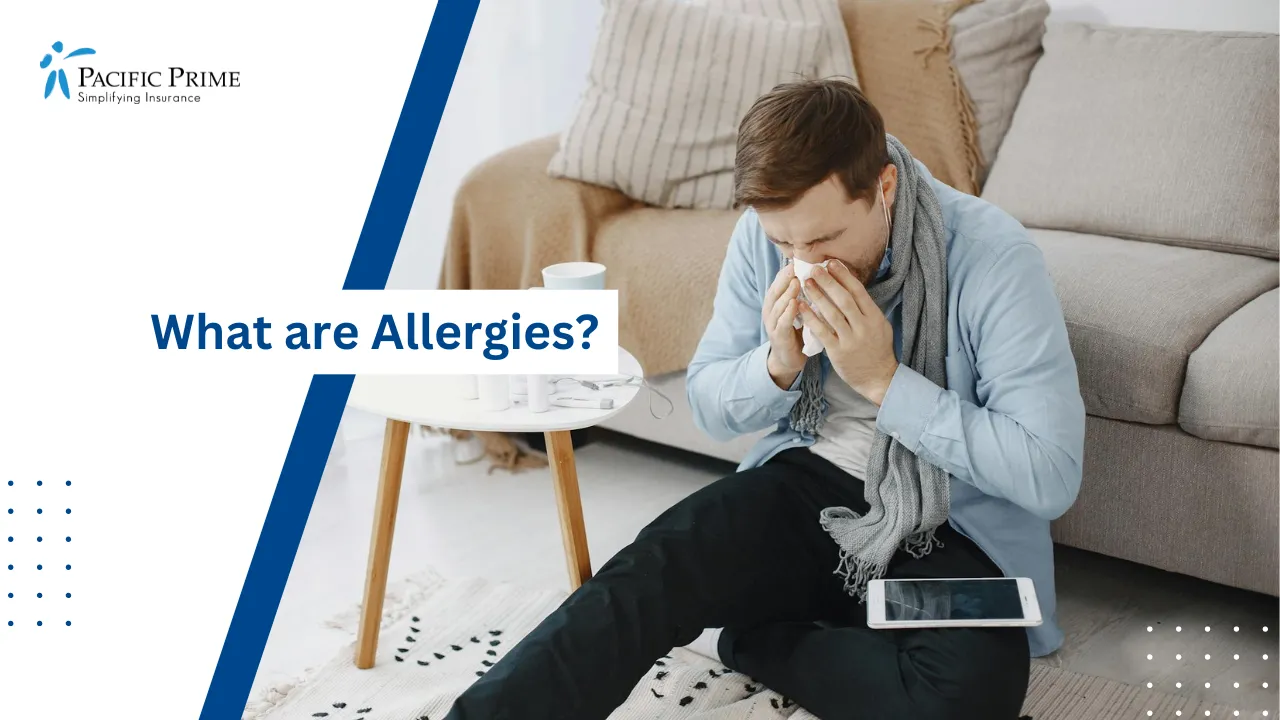 Image of Man Sneezing Into A Tissue While Sitting In A Living Room with text overlay of "What are Allergies?"