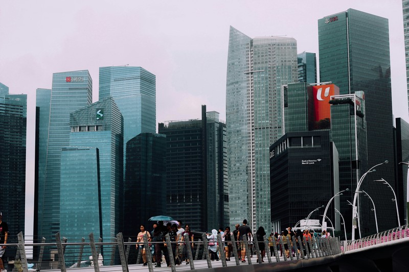 People On Bridge Among Buildings In Singapore