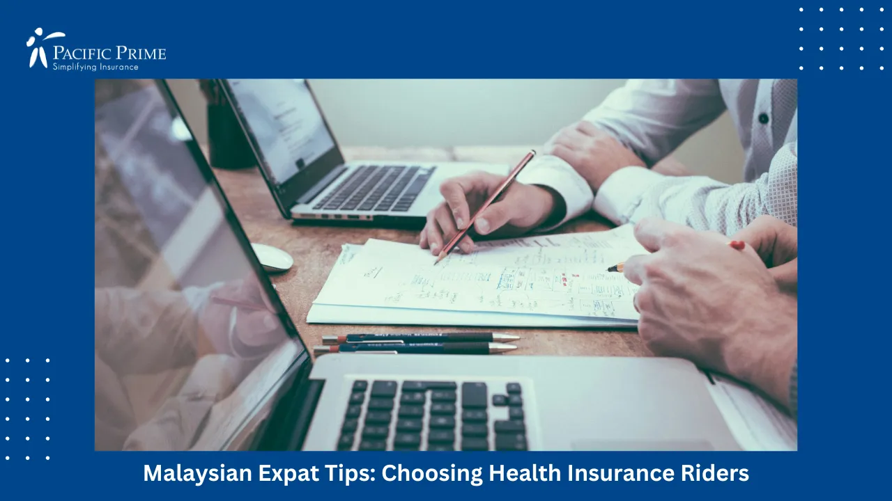 Image of Person Drafting Health Insurance Plans On Paper Beside Laptop with text overlay of "Malaysian Expat Tips: Choosing Health Insurance Riders"