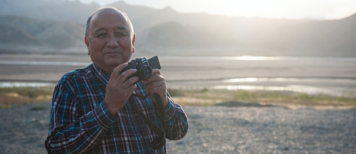 Old man traveling and taking pictures. He is healthy and happy because he takes good care of himself in retirement.
