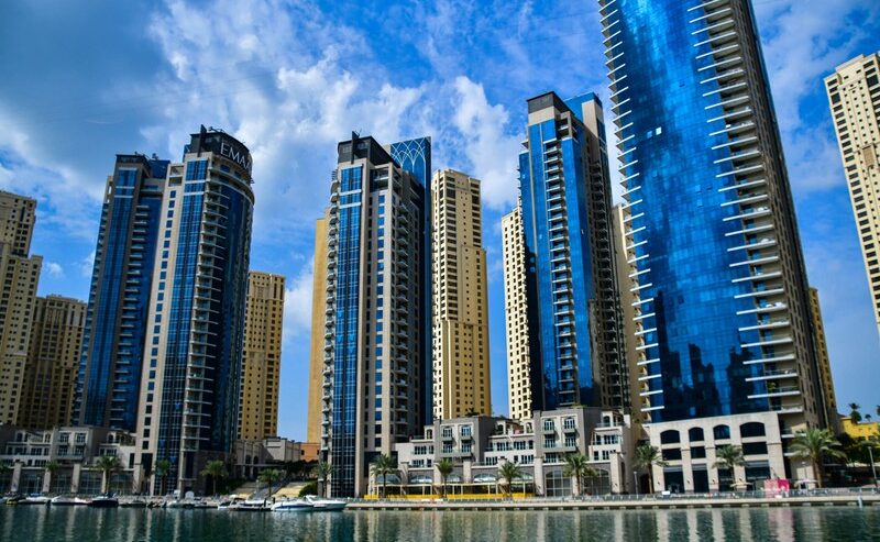 Skyscrapers by water in Dubai, symbolizing relocation from the UK