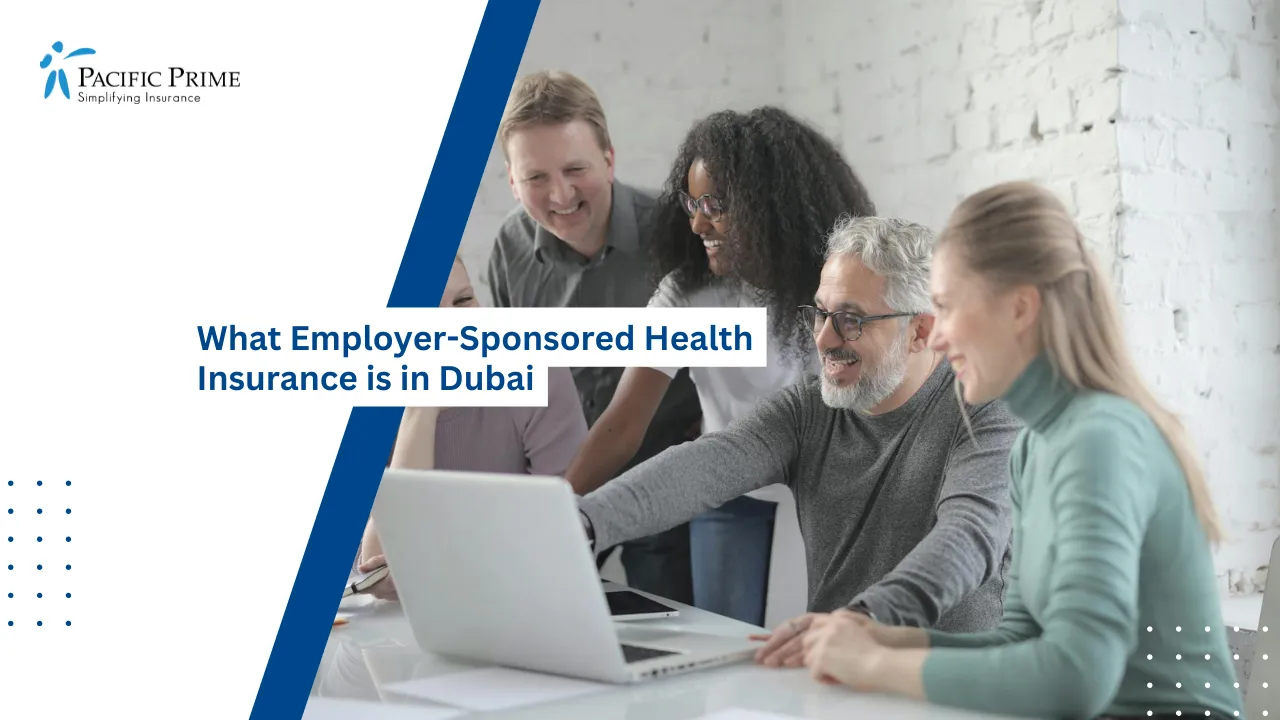 Image of Smiling Coworkers Collaborating On A Laptop In A Modern Office Space with text overlay of "What Employer-Sponsored Health Insurance is in Dubai"