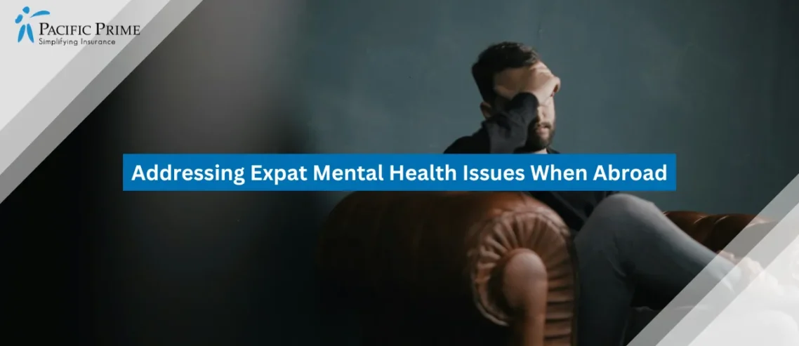 Image of Stressed Man Sitting On A Sofa Holding His Head with text overlay of "Addressing Expat Mental Health Issues When Abroad"