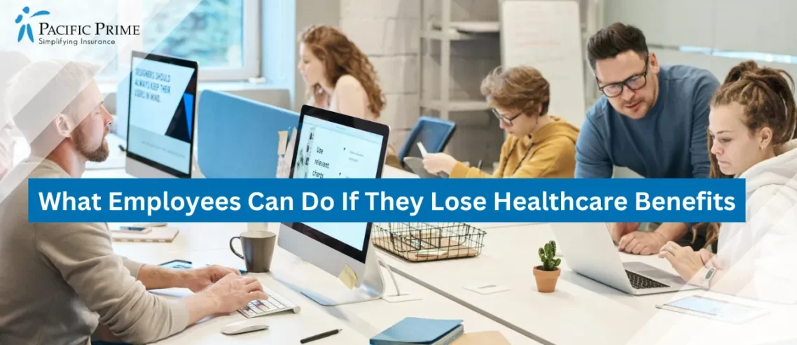 Image of Team Members Working On Computers In Office Setting with text overlay of "What Employees Can Do If They Lose Healthcare Benefits"