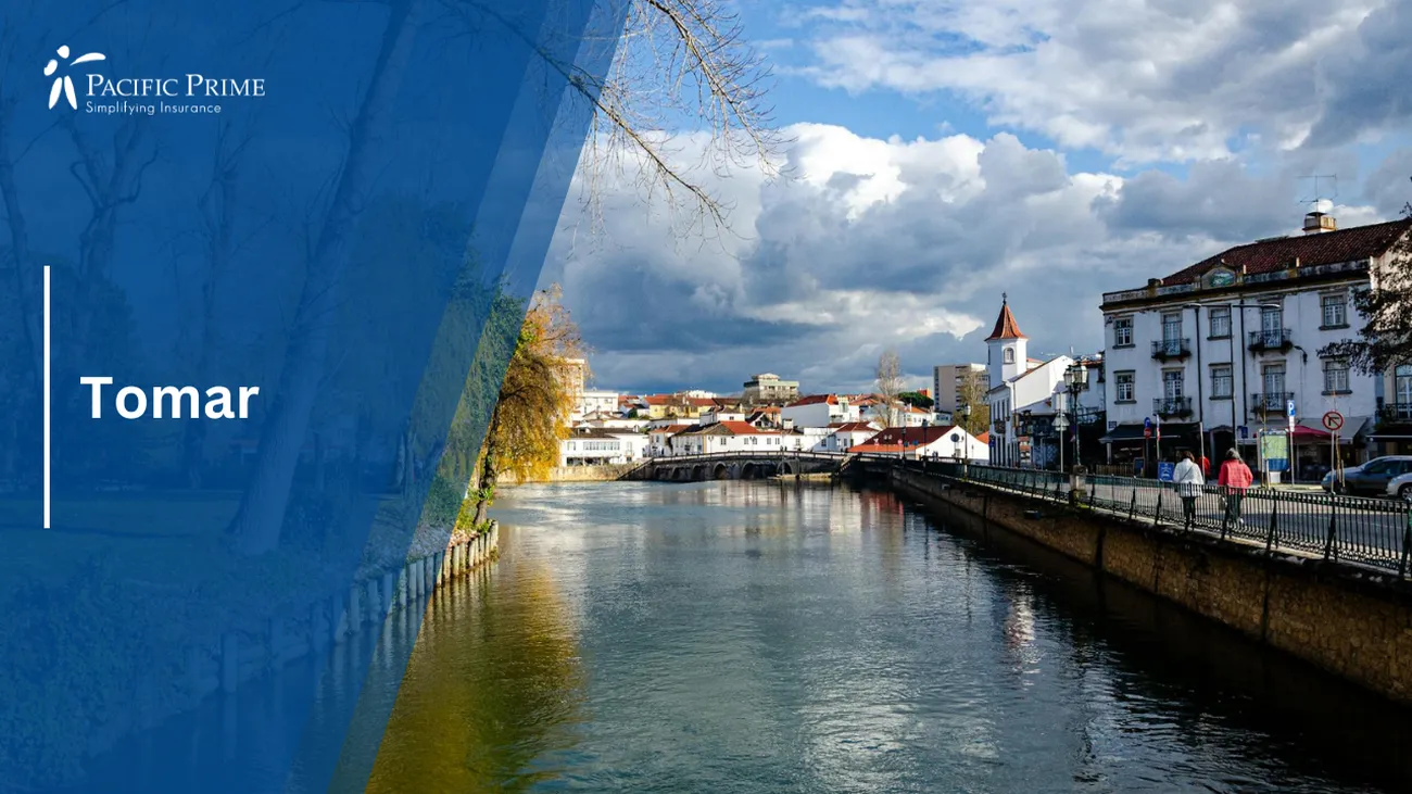 Image of Tomar, Santarém, Portugal: Concrete Buildings By River Under Cloudy Sky with text overlay of "Tomar"