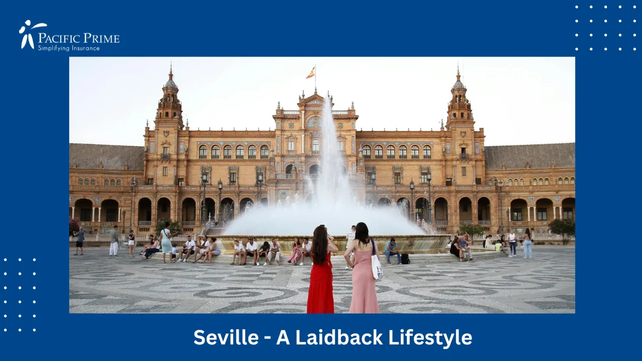 Image of Two Women In Red Dresses At A Seville Fountain with text overlay of "Seville - A Laidback Lifestyle"