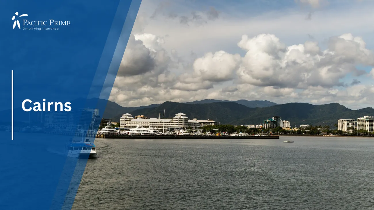 Image of White And Blue Boat On The Sea Under Cloudy Skies In Cairns, Australia with text overlay of "Cairns"