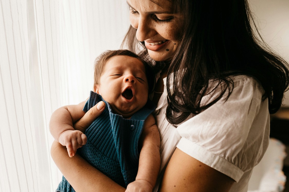Woman In White With Newborn In Blue